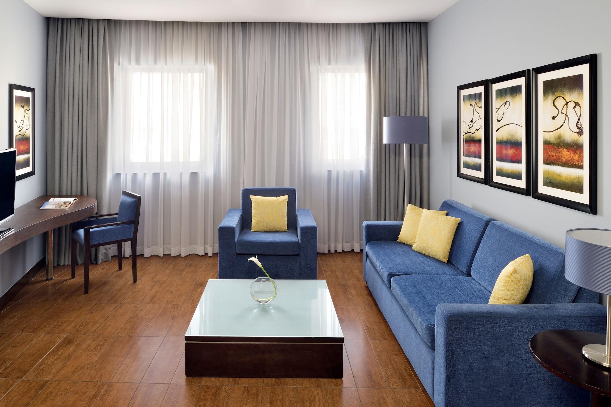 Moevenpick Hotel Apartments Al Mamzar Дубай Екстериор снимка A living room with a sofa